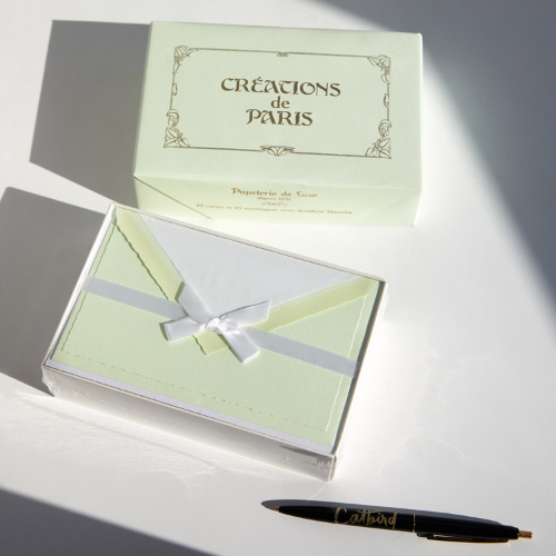 Creations De Paris green stationary set on tabletop with a black pen