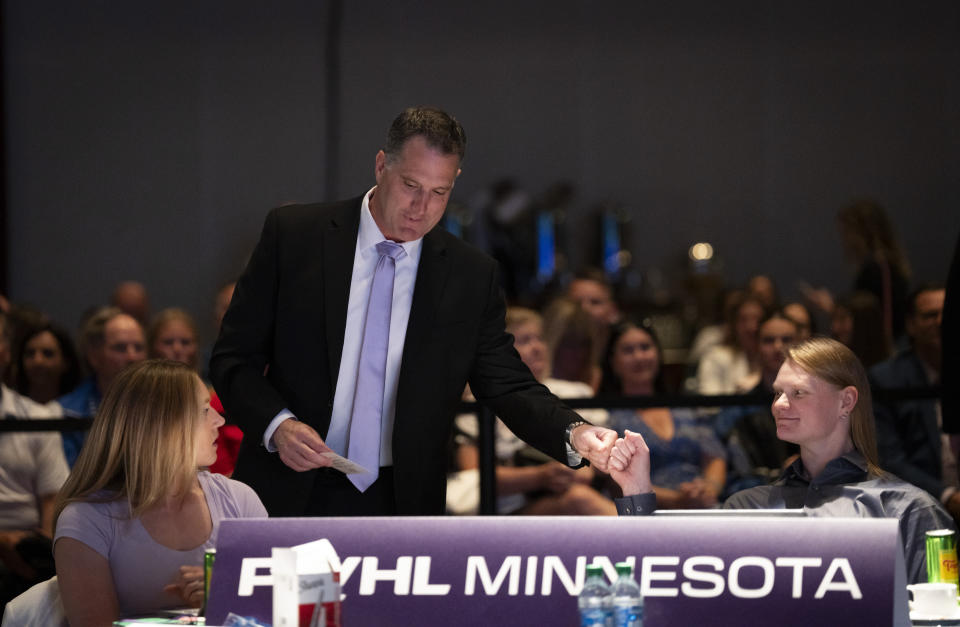 Minnesota head coach Ken Klee, top, fist pumps assistant coach Mira Jalosuo, right, at the Minnesota table before walking to the stage for the first Minnesota pick during the PWHL hockey draft in St. Paul, Minn., Monday June, 10, 2024. (Renée Jones Schneider/Star Tribune via AP)
