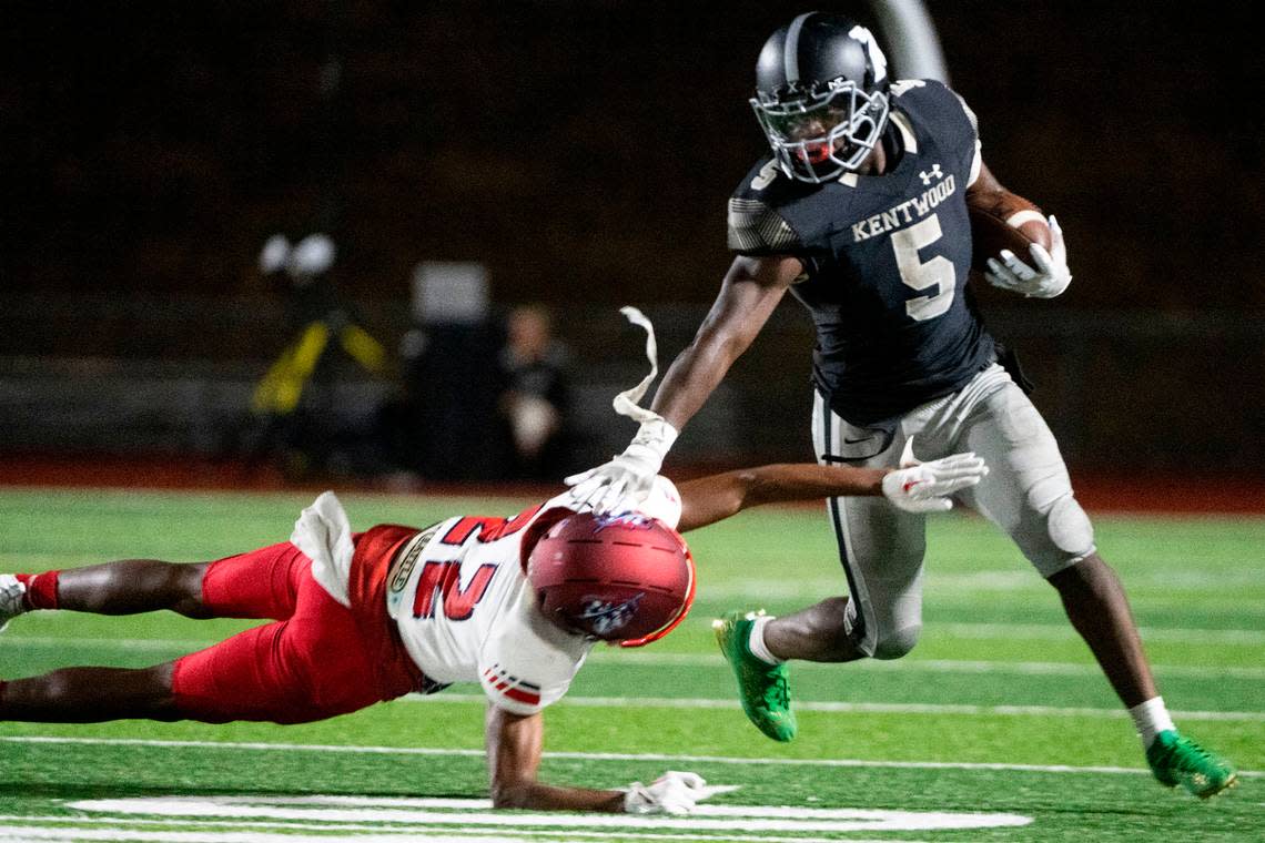 Kentwood running back Antoine Lee stiff arms Kennedy Catholic’s Geron White as he runs up the field during the fourth quarter of a 4A NPSL game on Thursday, Sept. 15, 2022, at French Field in Kent, Wash.