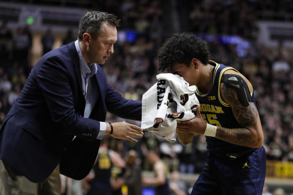 Michigan guard Eli Brooks (55) is assisted after being injured during the second half of an NCAA college basketball game against Purdue in West Lafayette, Ind., Saturday, Feb. 22, 2020. (AP Photo/Michael Conroy)