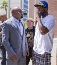 Rap artist 50 Cent, right, talks with Floyd Mayweather Jr.'s advisor, Leonard Ellerbe, after Mayweather turned himself in to begin a 90-day jail term, Friday, June 1, 2012, in Las Vegas. The undefeated five-division champion surrendered Friday before the judge who sentenced him in December for attacking his ex-girlfriend in September 2010 and then allowed him to remain free long enough to headline a May 5 fight. (AP Photo/Julie Jacobson)