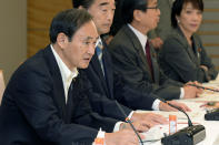 Then Chief Cabinet Secretary Yoshihide Suga, left, speaks at a meeting on food, agriculture and rural areas, at the prime minister's office in Tokyo Oct. 29, 2013. Japan's Parliament elected Suga as prime minister Wednesday, Sept. 16, 2020, replacing long-serving leader Shinzo Abe with his right-hand man. Suga has stressed his background as a farmer's son and a self-made politician in promising to serve the interests of ordinary people and rural communities. (Kyodo News via AP)