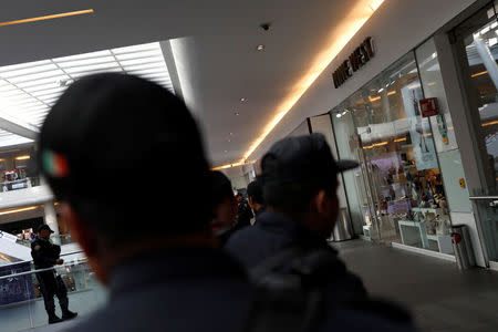 Police work outside a footwear shop after a man shot a woman in the abdomen there before shooting himself in the head according to a police statement in Mexico City, Mexico March 19, 2018. REUTERS/Carlos Jasso