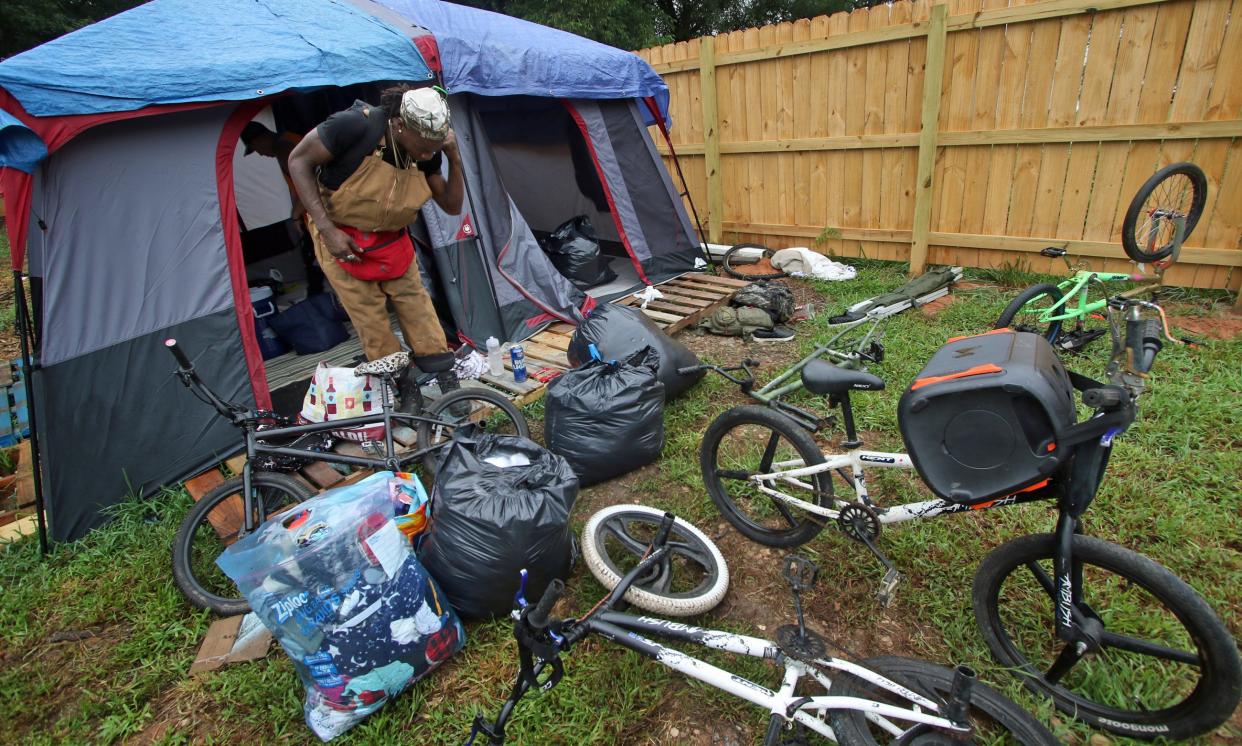 Jay Thomas packs up his belongings as he and others prepare to vacate the homeless encampment behind Faith, Hope and Love Community Enrichment Ministries on North Oakland Street early Monday morning.