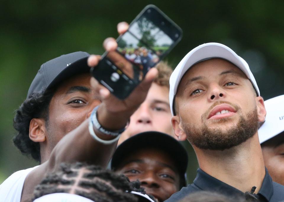 Bear Huff a player on the Underrated Golf tour grabs a selfie with Stephen Curry on the South Course at Firestone Country Club in Akron.