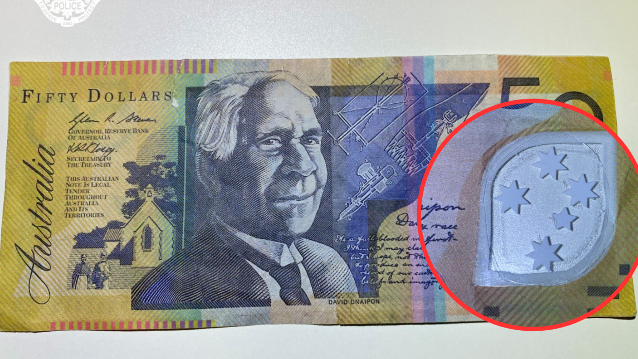 An image of a counterfeit $50 note with a zoomed in image of the picture window which shows the defects.