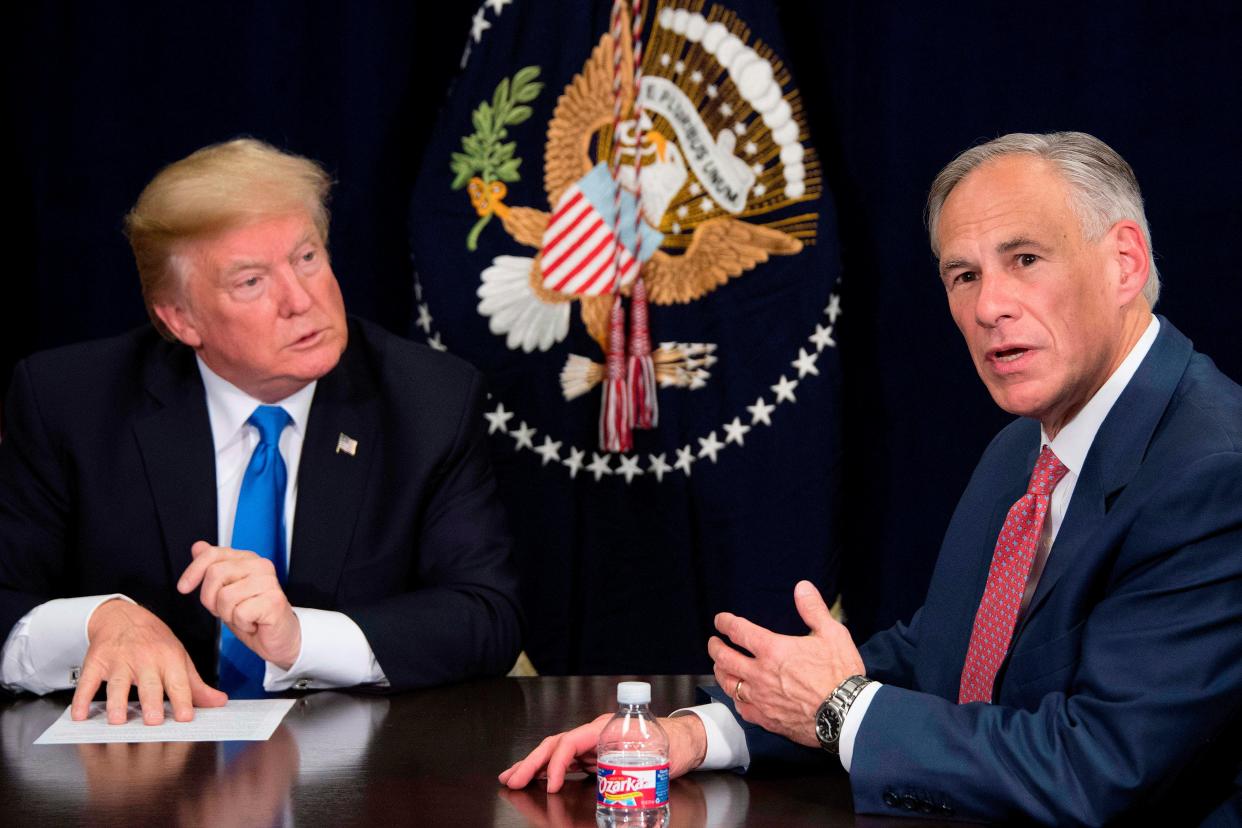 El gobernador de Texas, Greg Abbott (derecha), habla con el entonces presidente de los Estados Unidos, Donald Trump (izquierda), durante una sesión informativa sobre los esfuerzos de ayuda por el huracán en Dallas, Texas, el 25 de octubre de 2017. Abbott ha dicho que planea recaudar fondos para construir más muro fronterizo entre Estados Unidos y México. (AFP via Getty Images)