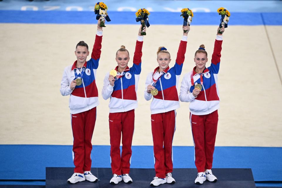 <p>Gold medalists Russia's Liliia Akhaimova, Russia's Angelina Melnikova Russia's Viktoriia Listunova and Russia's Vladislava Urazova celebrate on the podium after winning the artistic gymnastics women's team final during the Tokyo 2020 Olympic Games at the Ariake Gymnastics Centre in Tokyo on July 27, 2021. (Photo by Martin BUREAU / AFP) (Photo by MARTIN BUREAU/AFP via Getty Images)</p> 