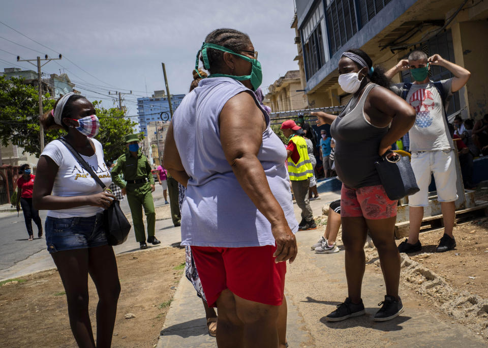 People wearing face masks amid the spread of the new coronavirus wait to enter a government-run food store in Havana, Cuba, Tuesday, May 19, 2020. State media has started a campaign of zero tolerance for anyone attempting to cash in on the fallout from the spread of the new coronavirus, like hoarding and speculative pricing, which has imposed even more distress on Cubans who were already used to shortages and long lines in their efforts to find basic necessities. (AP Photo/Ramon Espinosa)