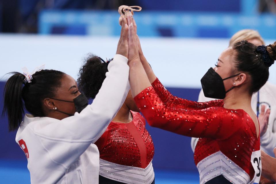 Simone Biles high fives Suni Lee.