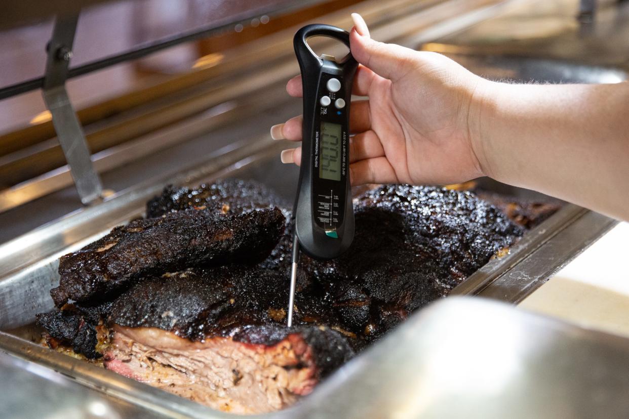 Joanie Garza, a public health inspector with the city, uses a thermometer to check the temperature of meat in warm holding during a restaurant inspection on June, 6 2023, in Corpus Christi, Texas.