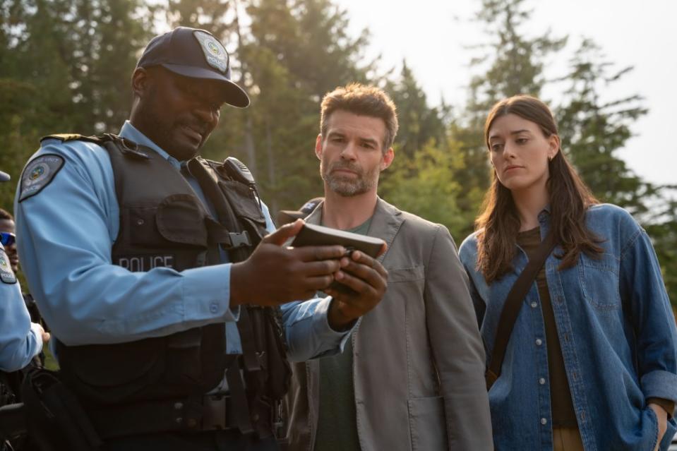 Avery (Lewis) and her partner, Jake Campbell (Daniel Gillies, center), peruse evidence in a homicide case. Michael Courtney/The CW