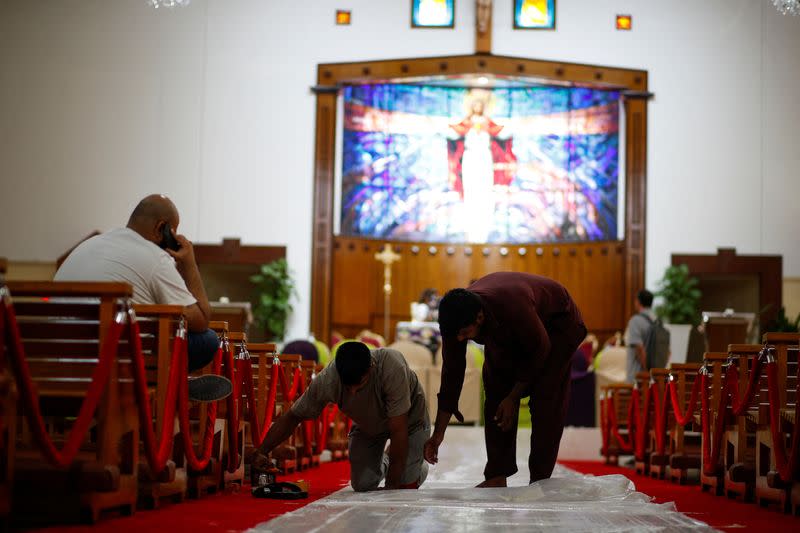 Workers take on last minute set up ahead of Pope Francis arrival at Sacred Heart Catholic Church in Manama