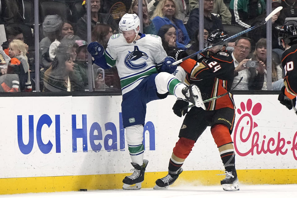 Vancouver Canucks center Sam Lafferty, left, battles for the puck with Anaheim Ducks center Bo Groulx during the first period of an NHL hockey game Sunday, March 3, 2024, in Anaheim, Calif. (AP Photo/Mark J. Terrill)