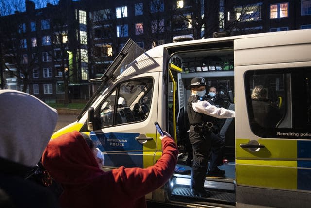 Police officers and special constables talk to local residents following a stop and search (Victoria Jones/PA)