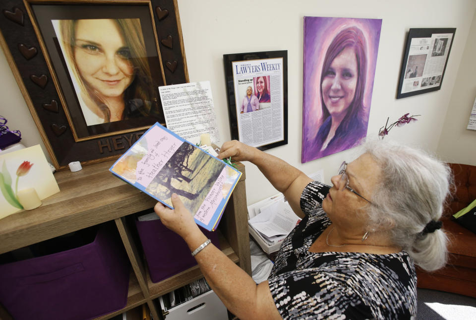 In this Monday, Aug. 6, 2018 photo, Susan Bro, mother of Heather Heyer, who was killed during the Unite the Right rally last year, looks over memorabilia in her office in Charlottesville, Va. "I just would like people to focus on the anniversary, not on Heather, but on the issues that she died for, Black Lives Matter, overpolicing, affordable housing, for more truth and the telling of the history of Charlottesville, and to focus on where they need to go as a community,” Bro said. (AP Photo/Steve Helber)