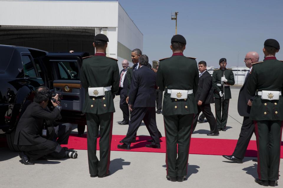 President Barack Obama, center, walks through an honor guard on arrival at Licenciado Adolfo Lopez Mateos International Airport in Toluca, Mexico, Wednesday, Feb. 19, 2014, to participate in the seventh trilateral North American Leaders Summit Meeting with Canadian Prime Minister Stephen Harper and Mexican President Enrique Peña Nieto. This year's theme is “North American Competitiveness.” (AP Photo/Jacquelyn Martin)