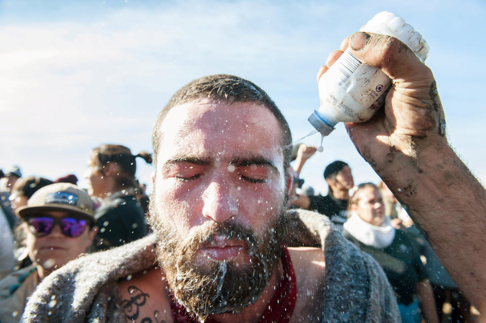 <p>A person pours a pepper spray antidote into a protester’s eyes during a protest against the building of a pipeline on the Standing Rock Indian Reservation near Cannonball, N.D., on Nov. 2, 2016. (Photo: Stephanie Keith/Reuters) </p>