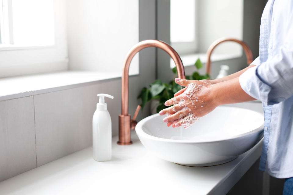 Woman washing hands under water tap. Self care and hygiene. Close up of female hand. Infection prevention. Liquid antibacterial soap and foam. Step by step instruction. Step 2.