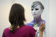 An artist paints a naked body during the IXth Cze ch Republic Body Painting Championships on March 31, 2012 as part of the ''Inter Beauty Prague 2012'' fair Prague. The theme of the contest is ''Lady from a picture of Czech Art Nouveau painter Alfons Mucha.''