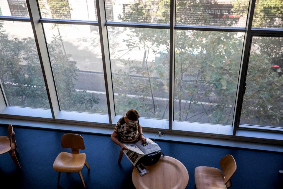 A visitor reads a newspaper at the Agusti Centelles Library, a designated climatic refuge, part of Barcelonas Climate Shelter Network (CSN)
