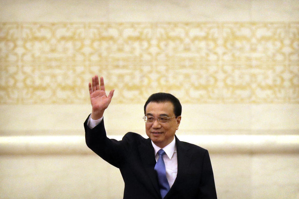 Chinese Premier Li Keqiang waves as he arrives for a press conference held after the closing session of China's National People's Congress (NPC) at the Great Hall of the People in Beijing, Friday, March 15, 2019. (AP Photo/Mark Schiefelbein)