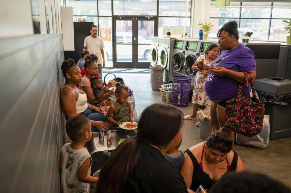 Customers eat free pizza and wait for their laundry to be finished on Community Laundry Day at Leah’s Laundromat on the Q in Kansas City, Kansas. “If someone comes in and needs to speak to someone because they don’t have food, they don’t have diapers, they don’t have formula, they’re homeless, there is someone here for them to talk to,” Leah McPherson said.