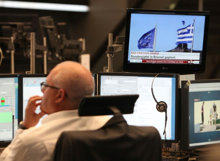 A trader works as news about Greece is seen on TV at the stock exchange in Frankfurt am Main, on July 6, 2015