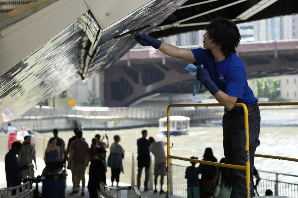 Ben Gallaido cleans the Chicago Riverwalk in Chicago, Monday, July 3, 2023, a day after heavy rains flooded Chicago streets and neighborhoods. (AP Photo/Nam Y. Huh)