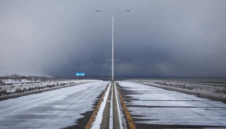 Storm clouds and snow blow from Lake Erie over the still-closed Route 5 highway in Lackawanna, near Buffalo, New York November 20, 2014. REUTERS/Aaron Lynett