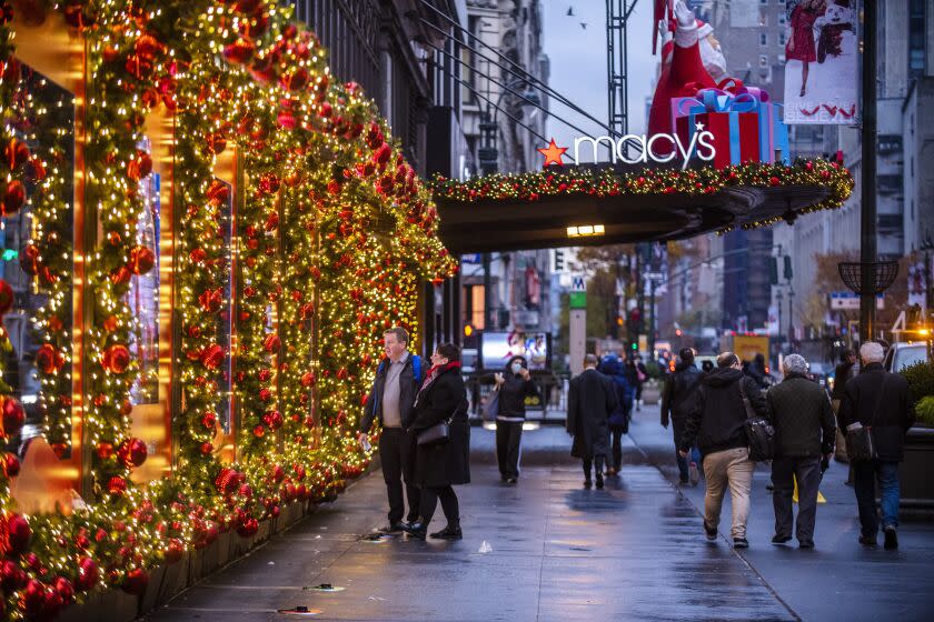 Black Friday shoppers enjoy the Macy's holiday window display on Friday, Nov. 26, 2021, in New York. Retailers are expected to usher in the unofficial start to the holiday shopping season today with bigger crowds than last year in a closer step toward normalcy. But the fallout from the pandemic continues to weigh on businesses and shoppers' minds. (AP Photo/Brittainy Newman)