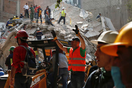 People clear rubble after an earthquake hit Mexico City, Mexico September 19, 2017. REUTERS/Carlos Jasso