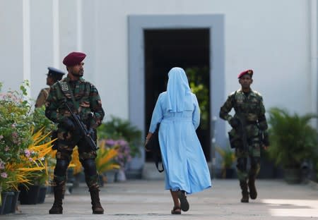 FILE PHOTO: A nun arrives as a Sri Lanka's commando soldier stands guard in front of the main entrance to St. Lucia Cathedral as survivors and families of victims of Sri Lanka's Easter Sunday bombing arrive for a special mass for those who lost their lives