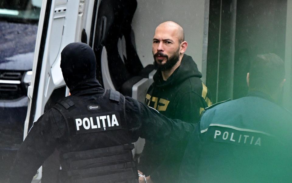 Andrew Tate is led by police officers to the Court of Appeal in Bucharest, Romania, on Tuesday