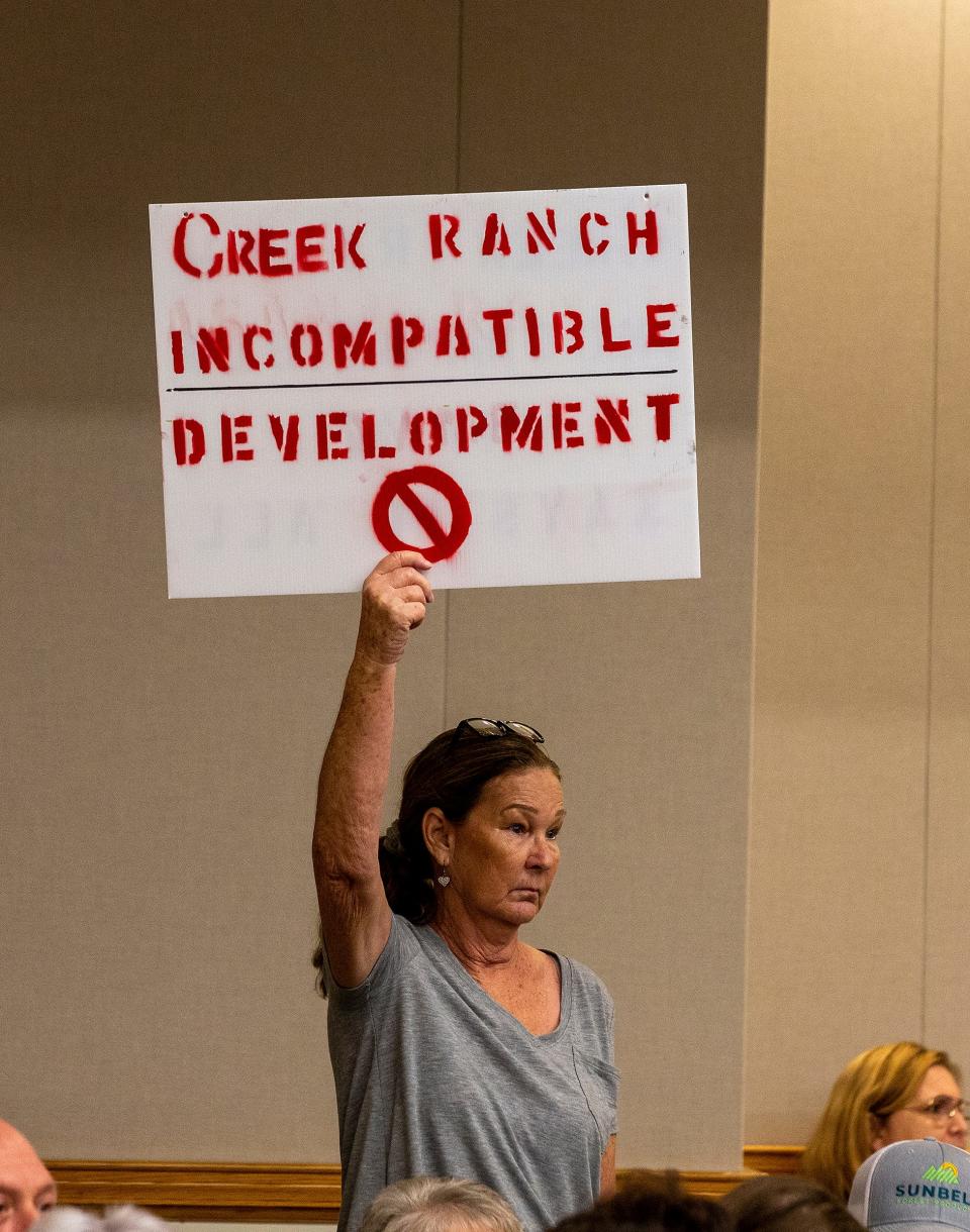 Debra Lawson holds a sign protesting a proposed development off Hatchineha Road during a Polk Planning Commission hearing in August.