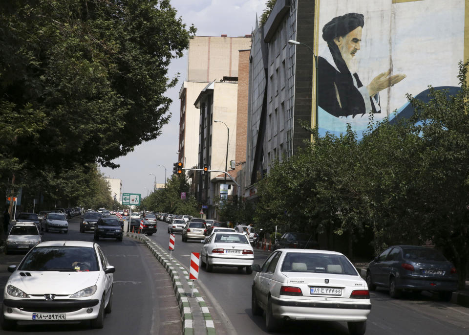 Cars drive under a portrait of the late Iranian revolutionary leader Ayatollah Khomeini in Tehran, Iran, on July 7, 2015.