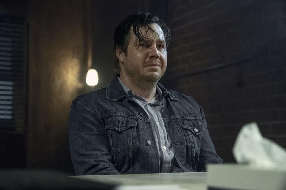 Josh McDermitt as Eugene sits at a table with a tissue box on it while he cries