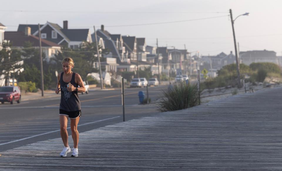 A runner enjoys the relative cool of an early-morning run on the Seaside Park boardwalk.