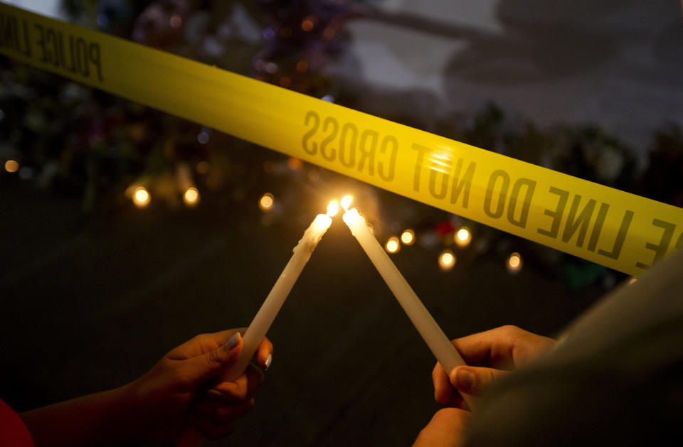 Olina Ortega, left, and Austin Gibbs light candles at a sidewalk memorial in front of Emanuel AME Church where people were killed by a white gunman Wednesday during a prayer meeting inside the historic black church in Charleston, S.C., Thursday, June 18, 2015. (AP Photo/David Goldman)