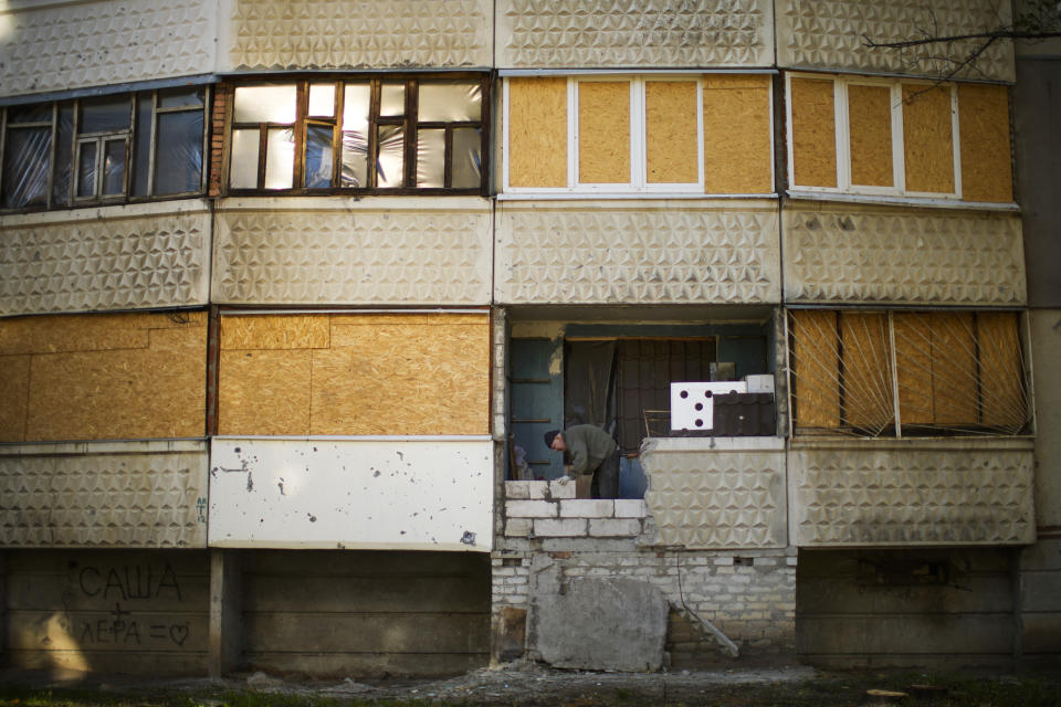 Ukrainian Hryhorii Ivanovich, 67, repairs his home balcony that was destroyed by a Russian rocket in Saltivka residential district, north Kharkiv, Ukraine, Saturday, Oct. 15, 2022. (AP Photo/Francisco Seco)