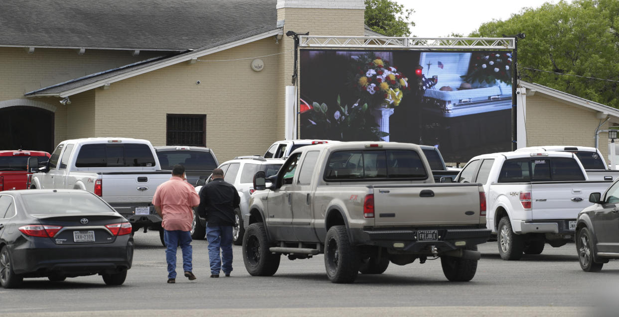 Due to the COVID-19 outbreak, funeral services, like the one depicted at Mission Park Funeral Chapels, are shown on an outdoor screen to drive-up attendees. (AP Photo/Eric Gay)