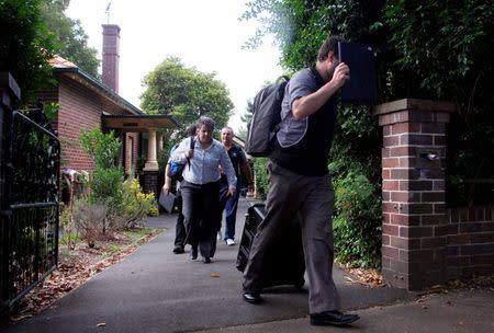 Officers from the Australian Government Tax Department, along with Australian Federal Police, walk down the driveway after searching the rented home of probable creator of cryptocurrency bitcoin Craig Wright in Sydney's north shore, Australia, December 9, 2015. REUTERS/David Gray/File Photo