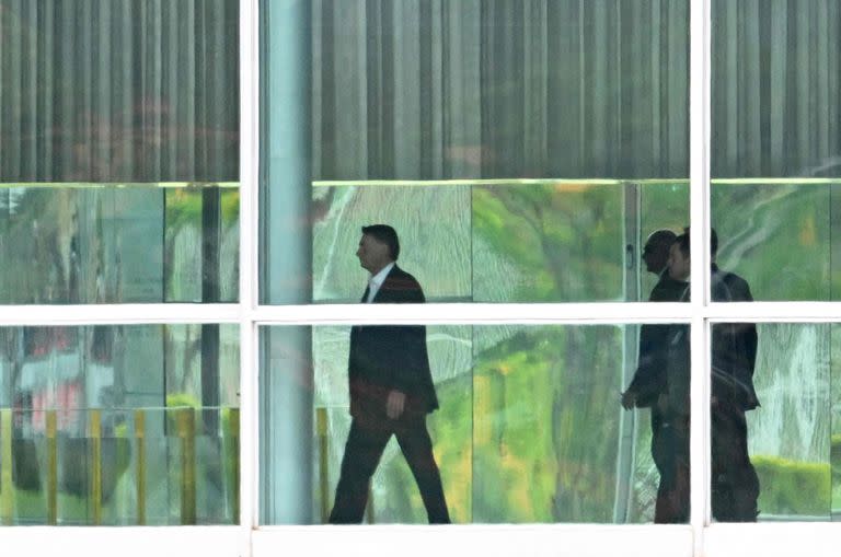 TOPSHOT - El presidente brasileño, Jair Bolsonaro (C), camina en el Palacio Alvorada en Brasilia, el 31 de octubre de 2022, un día después de la segunda vuelta de las elecciones presidenciales. - Un Brasil tenso esperaba el próximo movimiento de Jair Bolsonaro el lunes, ya que el titular de extrema derecha permaneció en silencio después de perder una segunda vuelta en la elección presidencial ante el veterano izquierdista Luiz Inacio Lula da Silva, quien ahora enfrenta una lista difícil de hacer. Bolsonaro fue derrotado por Lula con un puntaje de 51 por ciento contra 49 por ciento, la carrera más reñida desde que Brasil regresó a la democracia después de su dictadura militar de 1964-1985. (Foto por EVARISTO SA / AFP)