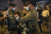 Israeli border police officers arrest an Ultra-Orthodox Jewish man during a protest against lockdown that has been placed in their neighborhood due to a coronavirus outbreak, in Jerusalem, Monday, July 13, 2020. As Israel grapples with a spike in coronavirus cases, it has begun to impose restrictions on selected towns and neighborhoods with high infection rates. Many of these areas are ultra-Orthodox, and residents say they are being unfairly singled out. (AP Photo/Oded Balilty)