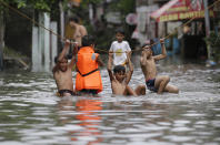 <p>Jungen hangeln sich über ein Seil, das über eine überflutete Straße in der philippinischen Hauptstadt Manila gespannt wurde. In dem asiatischen Land kam es in den vergangenen Tagen zu heftigen Regenfällen. (Bild: AP Photo/Aaron Favila) </p>