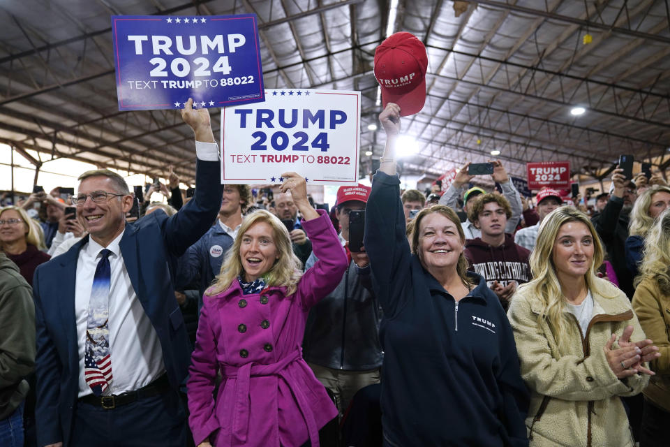 Audience members react as former President Donald Trump arrives at a commit to caucus rally, Monday, Oct. 16, 2023, in Adel, Iowa. (AP Photo/Charlie Neibergall)