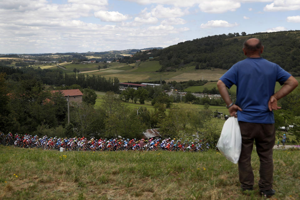 A man watches the pack during the ninth stage of the Tour de France cycling race over 170.5 kilometers (105.94 miles) with start in Saint Etienne and finish in Brioude, France, Sunday, July 14, 2019. (AP Photo/Thibault Camus)