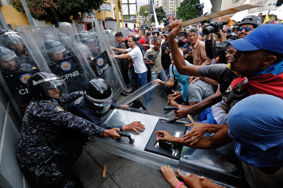 Opposition protesters clash with police blocking their march in Caracas, Venezuela, Tuesday, March 10, 2020. U.S.-backed Venezuelan political leader Juan Guaido is leading a march aimed at retaking the National Assembly legislative building, which opposition lawmakers have been blocked from entering. (AP Photo/Ariana Cubillos)