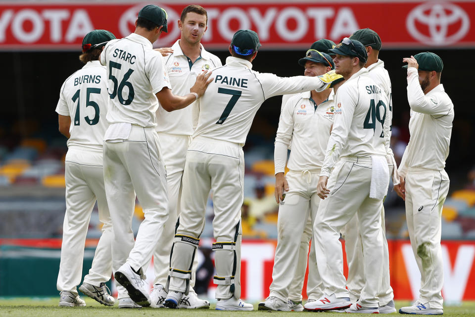 Australia's Josh Hazlewood, third from left without a cap, celebrates with his teammates after getting the wicket of Pakistan's Babar Azam during their cricket test match in Brisbane, Australia, Sunday, Nov. 24, 2019. (AP Photo/Tertius Pickard)