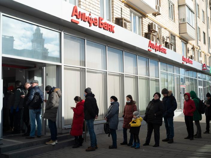 People stand in line to withdraw money from an ATM of Alfa Bank in Moscow, Russia, Sunday, Feb. 27, 2022.